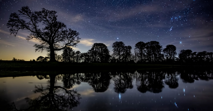 Raby Castle lake with starry sky above.